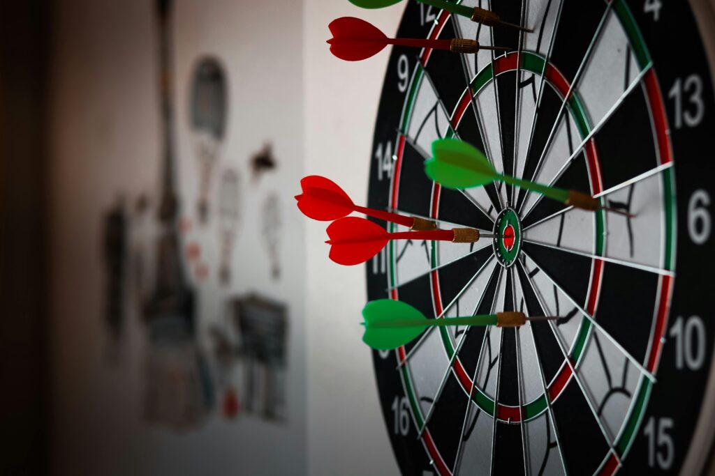 Close-up of a dartboard with multiple darts hitting the target, emphasizing precision and focus.